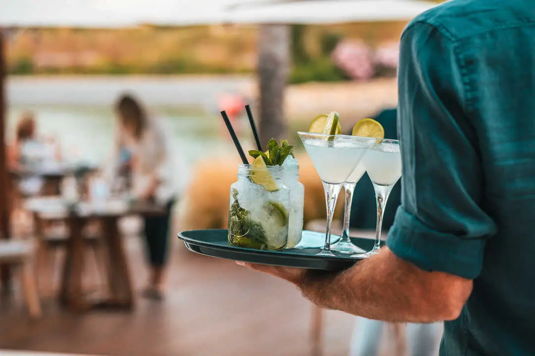 Camarero sirviendo bebidas en The Beach.